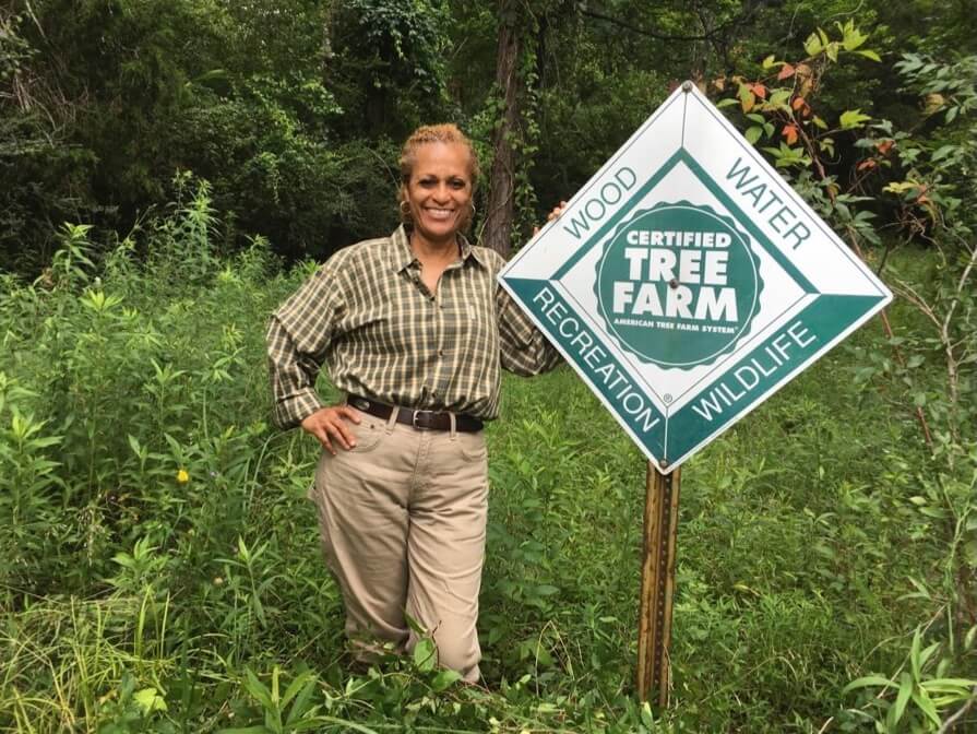 Landowner Vickie Roberts Ratliff of Winona, Mississippi, stands by the certified tree farm sign on her property.