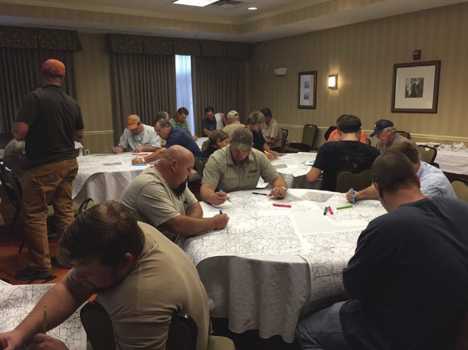 A room of men sitting around tables