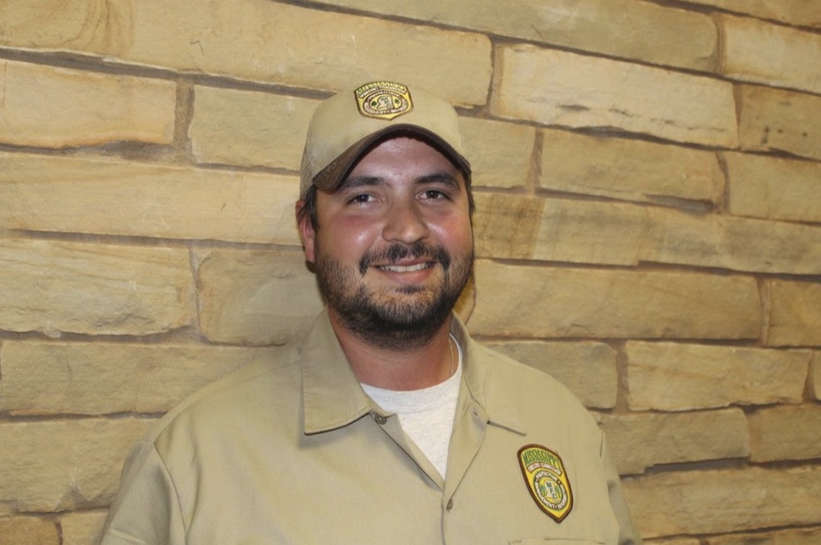 A firefighter standing in front of a stone wall.