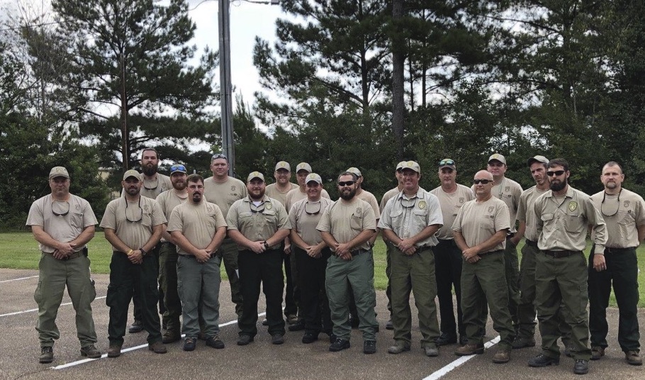 Twenty Wildland Firefighters standing in a parking lot