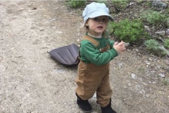 a young girl in the woods holding a shovel